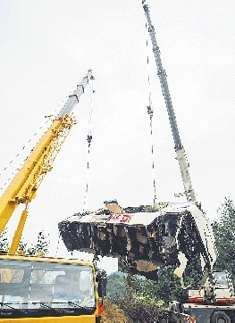 19日，吊車將事故車輛從山坡下吊起。 新華社發