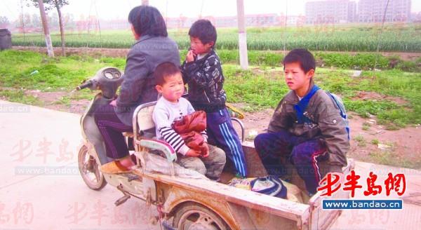 2011年底一名孩子在三輪車上趕作業。一年半過去了，這樣的場景仍隨處可見。